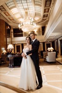 Brautpaar in eleganter Hotellobby mit Kronleuchter, Luxushochzeit Berlin – Spreejuwel Hochzeiten