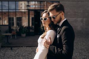 Brautpaar vor urbaner Glasfassade, moderne Hochzeit Berlin – Spreejuwel Hochzeiten
