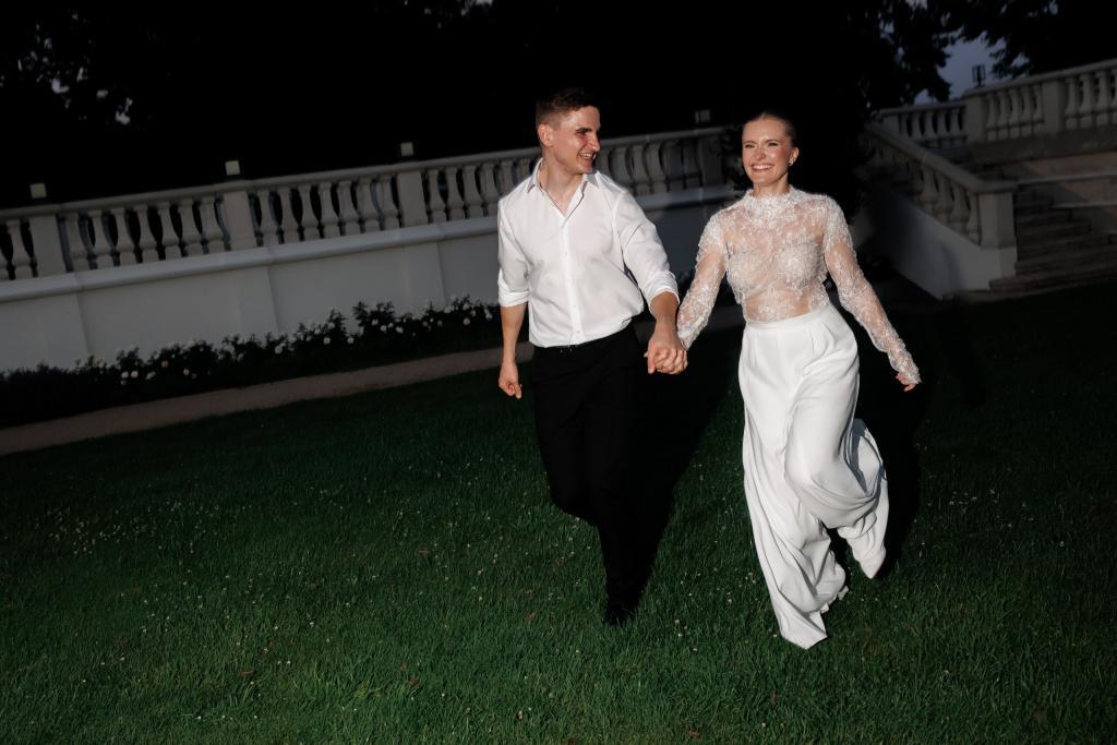 Brautpaar läuft bei Nacht Hand in Hand über die Wiese der Villa Aurea in Potsdam – Elopement Hochzeit in Brandenburg, Spreejuwel Hochzeiten