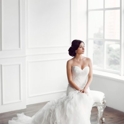 Braut vor dem Fenster auf einem Hocker